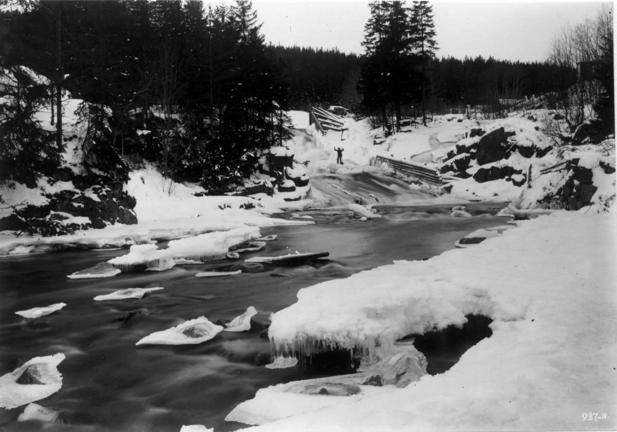 Hermann Christian Neupert, Oslo, Hammeren, Maridalen 1909. Vinterbilde av elvestryk. Mann står ved bredden. Skog.