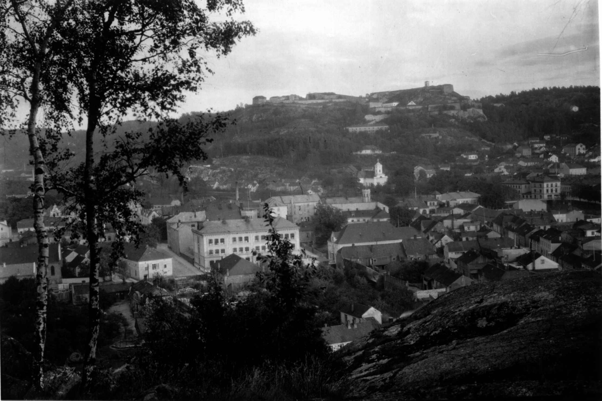 Hermann Christian Neupert, Halden, Østfold. 1930. Oversiktsbilde med Fredriksten festning i bakgrunnen. Kirke. Berg. Skog.