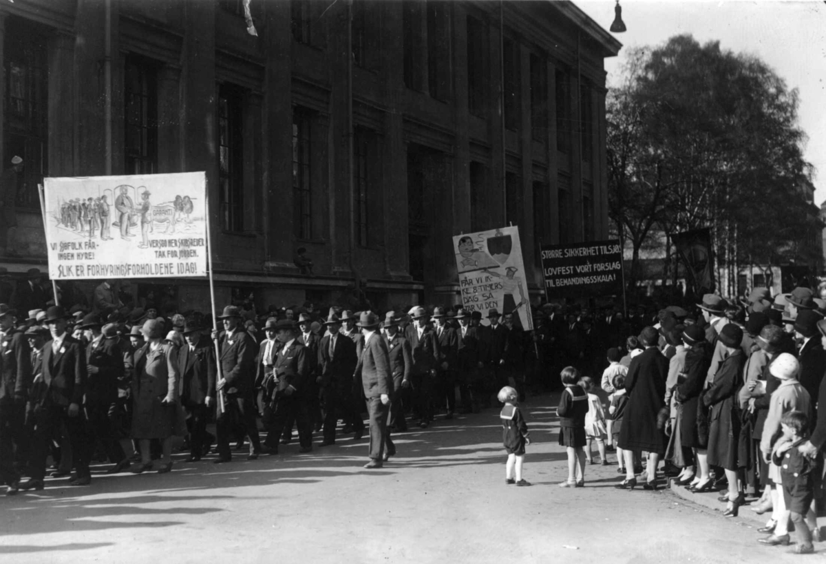 Hermann Christian Neupert, 1. mai-tog i Oslo 1930. Marsjerende menn og kvinner. Paroler. Tilskuere. Barn i matrosdrakt..