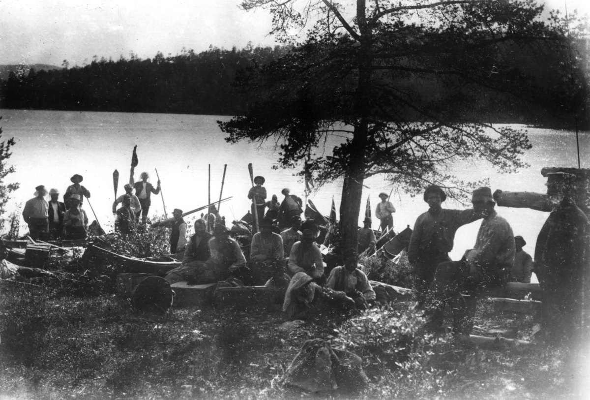 Ellisif Rannveig Wessel, Fra grenseoppgang i Sør-Varanger, Finnmark, antatt 1897-1899. Gruppe mennesker med båter samlet ved vannkanten.