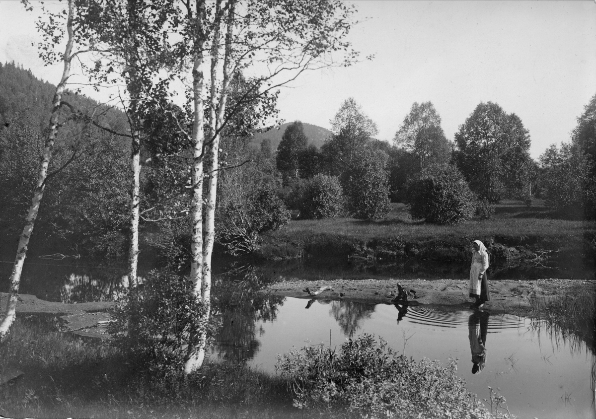 Robert Collett, Landskap med vadende kvinne i folkedrakt, ukjent sted. Serie tatt av Robert Collett (1842-1913), amatørfotograf og professor i zoologi.
