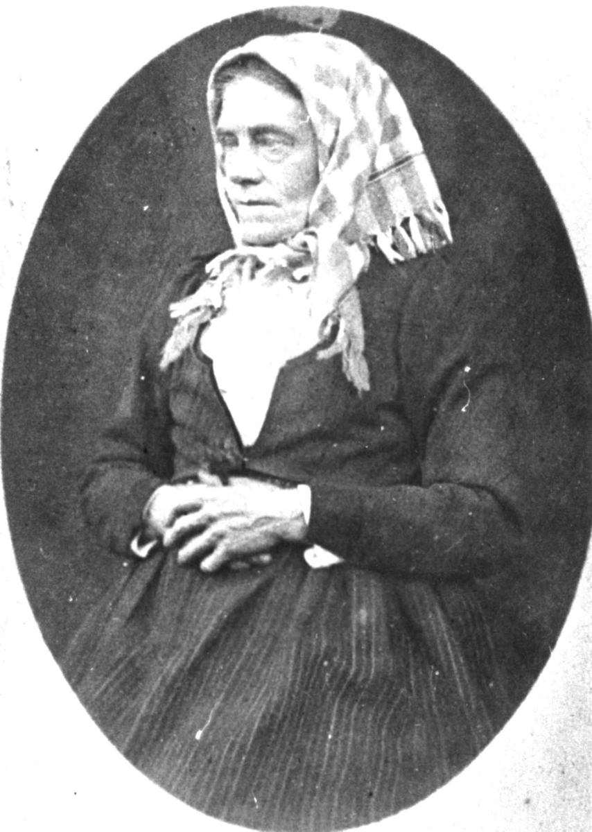 Anna Grostøl, Portrett av Mari Sundet, født Grindheim, i kvinnedrakt fra Vest-Agder. Gift 1849 med enkemann Søren Larsson Skjeggestad, Skjeggestad i Bjelland kommune, nå Marnardal kommune. Ble enke med 5 barn og flyttet til gården Sundet i Bjelland. Tok da navnet Sundet. Fra Anna Grostøls samlinger.
