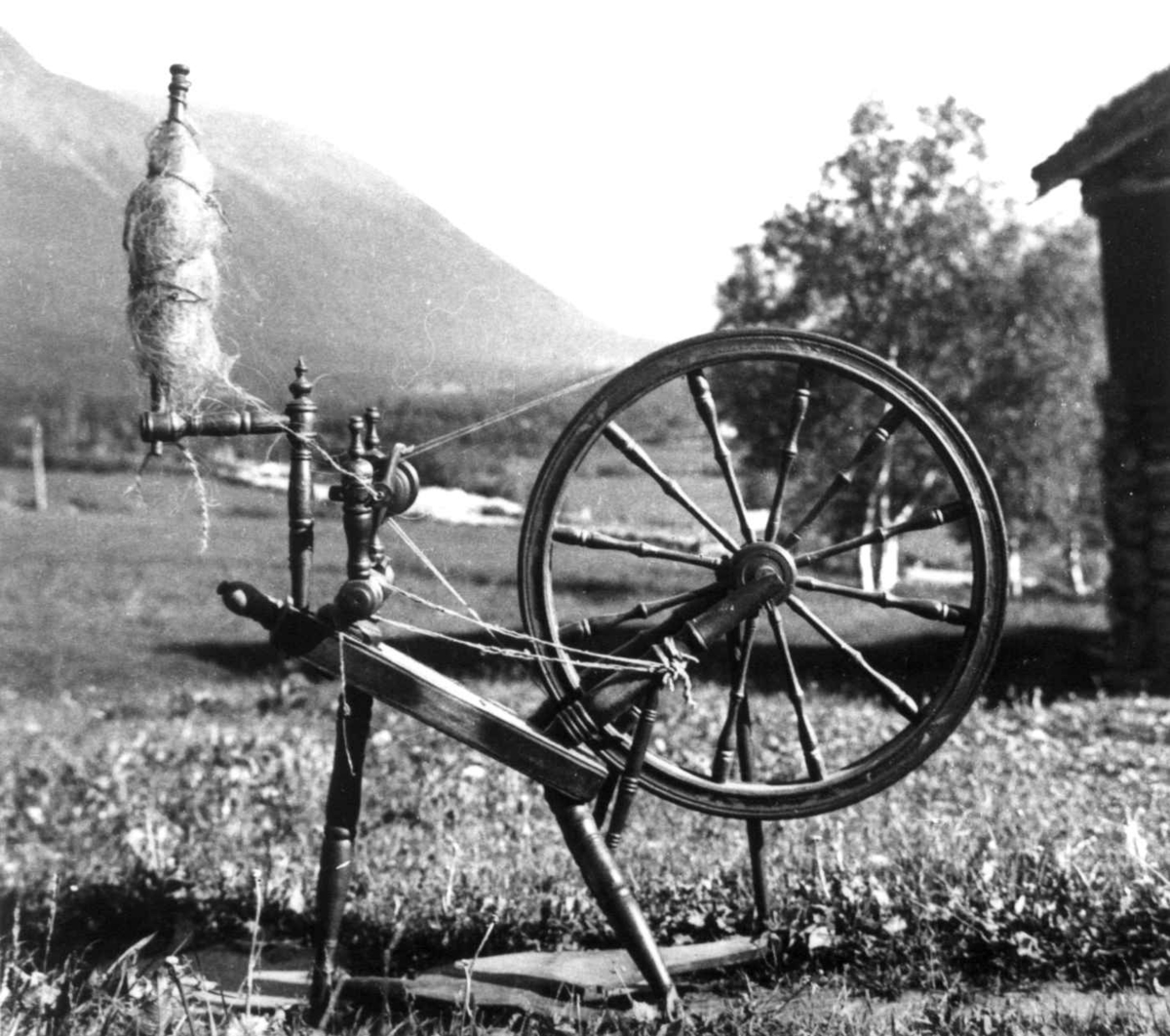 Anna Grostøl, Rokken på stensboeng med rokkehode med kutagl til spinning. Oppdal, Sør-Trøndelag 1934.