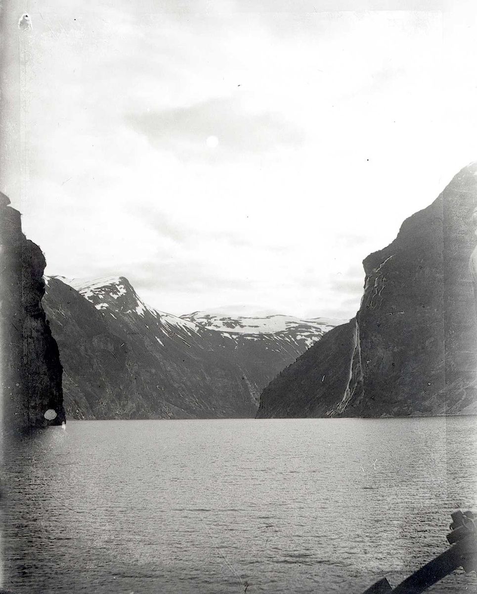 Tom Kent, Fjord med bratte fjell og snødekkede topper. Fosser i fjellsidene. Stranda, Geirangerfjord.