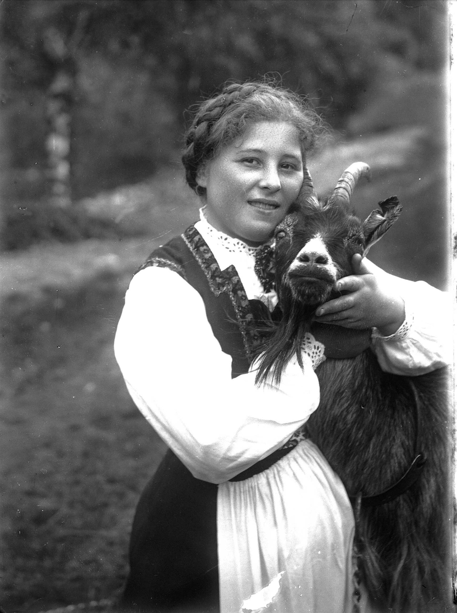 Solveig Lund, Kvinne i nasjonaldrakt klapper geit.