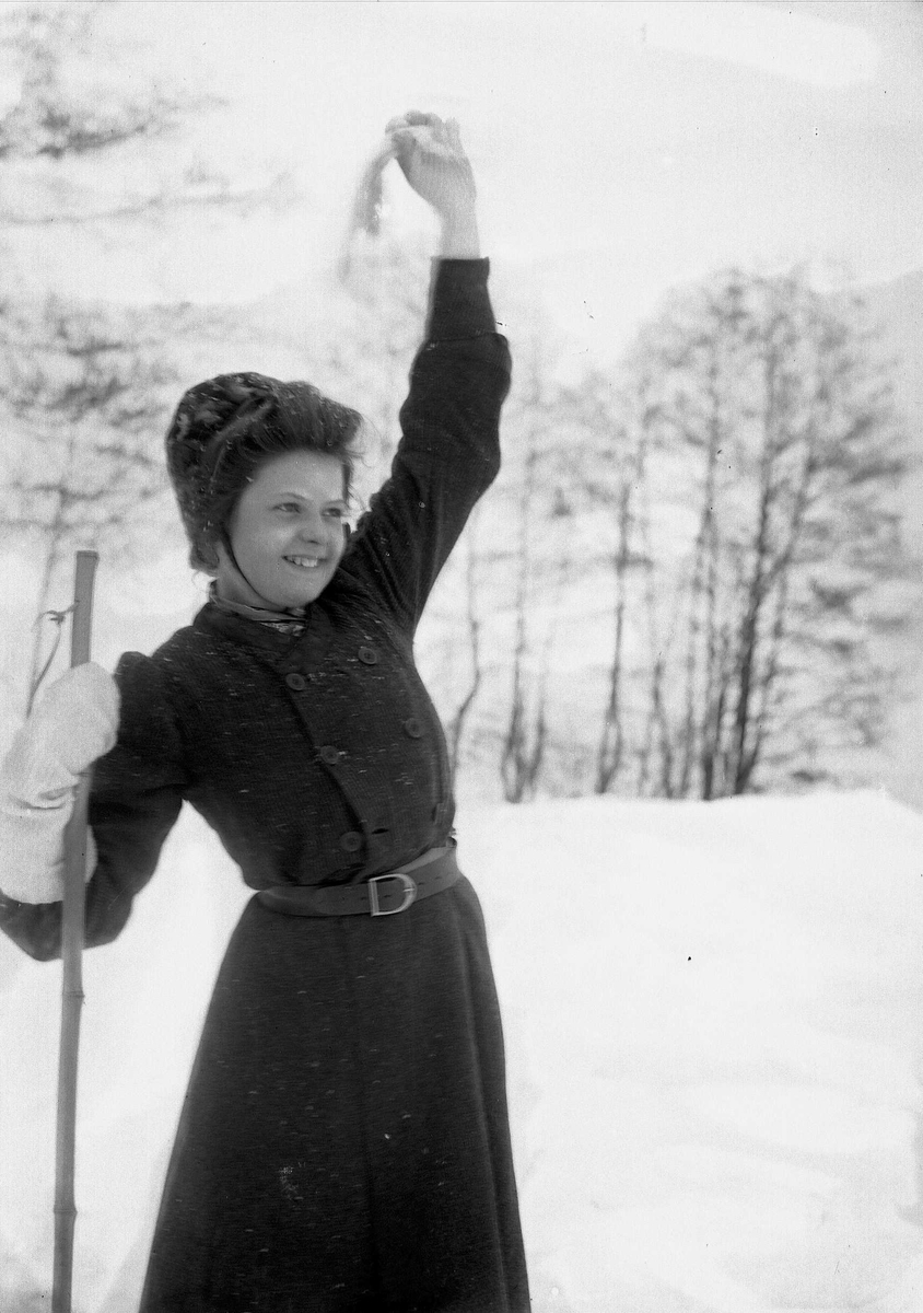 Solveig Lund, Kvinne i snødekt landskap. Hun har ski på beina og vinker med den ene votten.