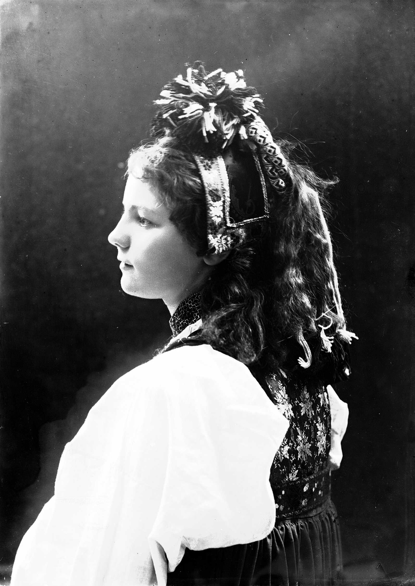 Solveig Lund, Studioportrett av kvinne i drakt og hodeplagg. Avfotografert fra siden.