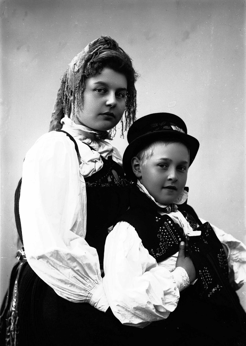 Solveig Lund, Studioportrett av kvinne i drakt og skaut og gutt i drakt og hatt.