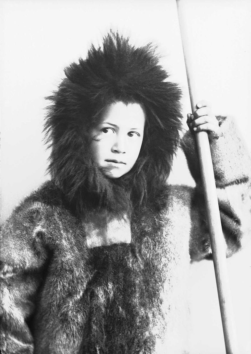 Solveig Lund, Gutt i sameliknende drakt med pesk og skinnlue, som holder en stav.