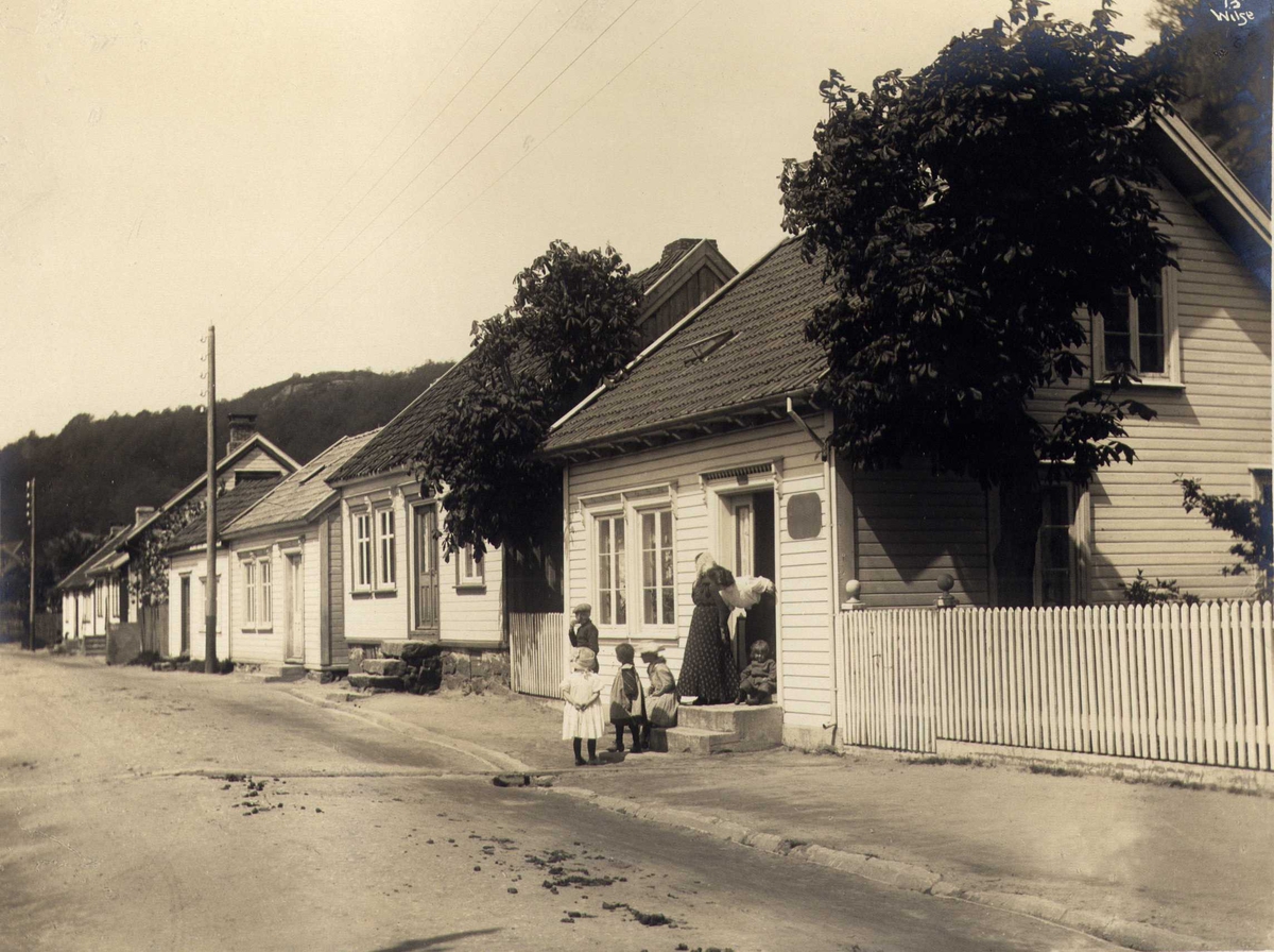 Anders Beer Wilse, Gateparti, Mandal, Vest-Agder. Fotografert 1912. Dame med 5 barn i forgrunn.