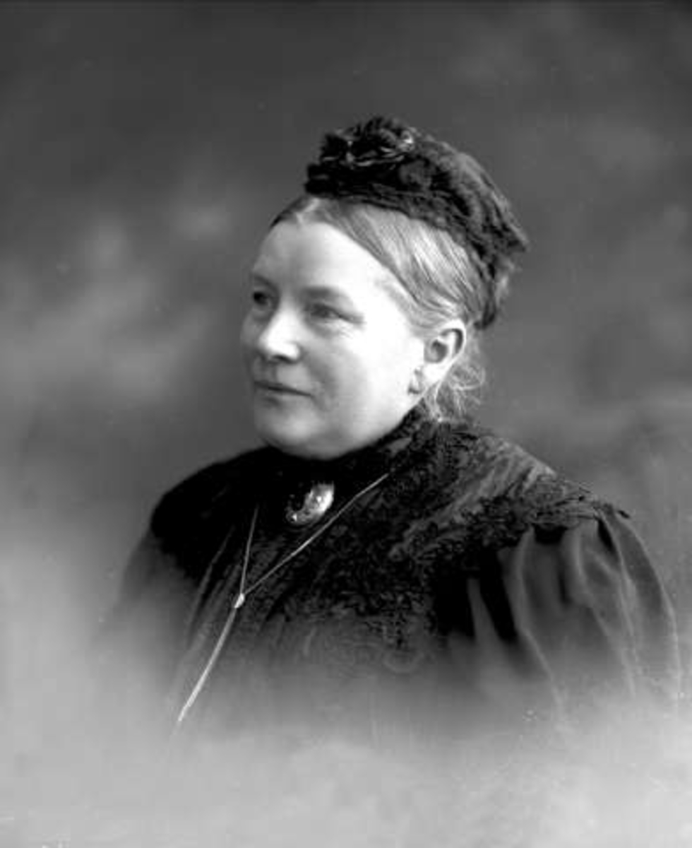 Gustav Borgen, Portrett, kvinne i mørk drakt med hodeplagg. Fru kaptein Olsen