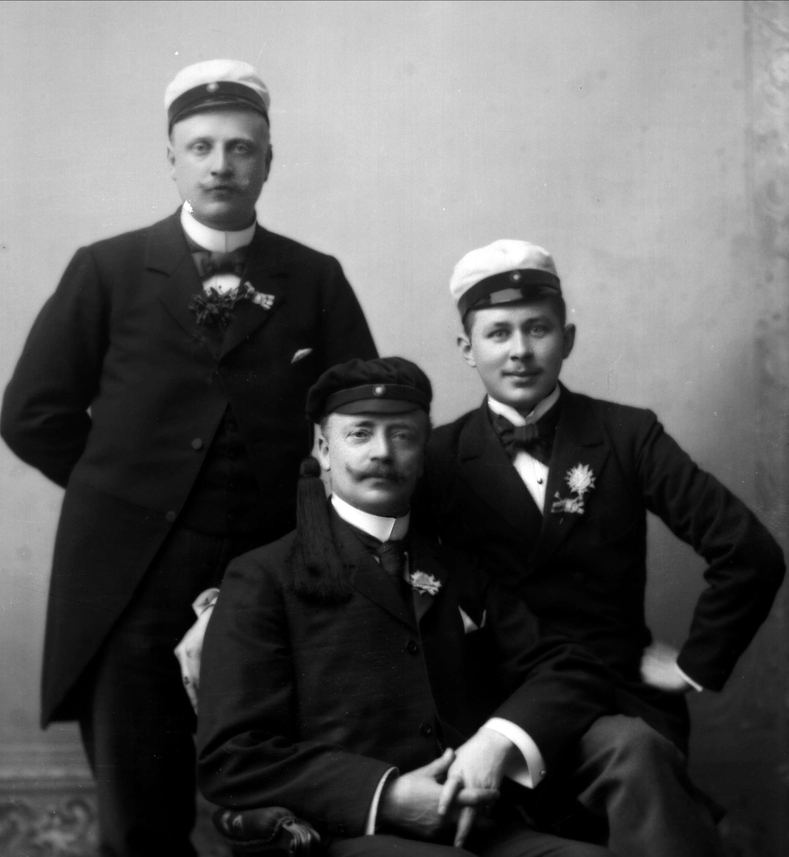 Gustav Borgen, Gruppeportrett, tre menn med lue, studentlue og to hvite luer.