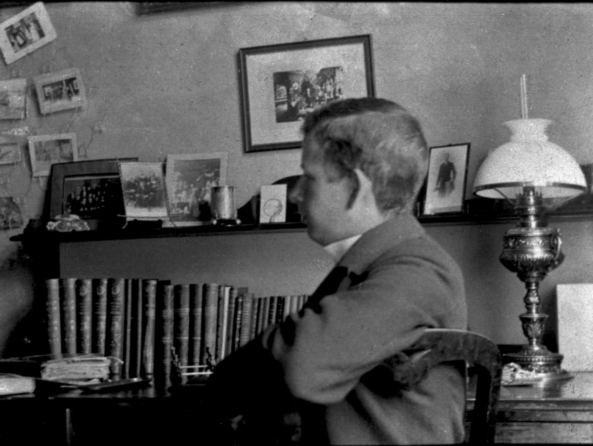 Gustav Borgen, Portrett, gutt sittende ved skrivepult med bøker. Skolebestyrer Andersen sønn.