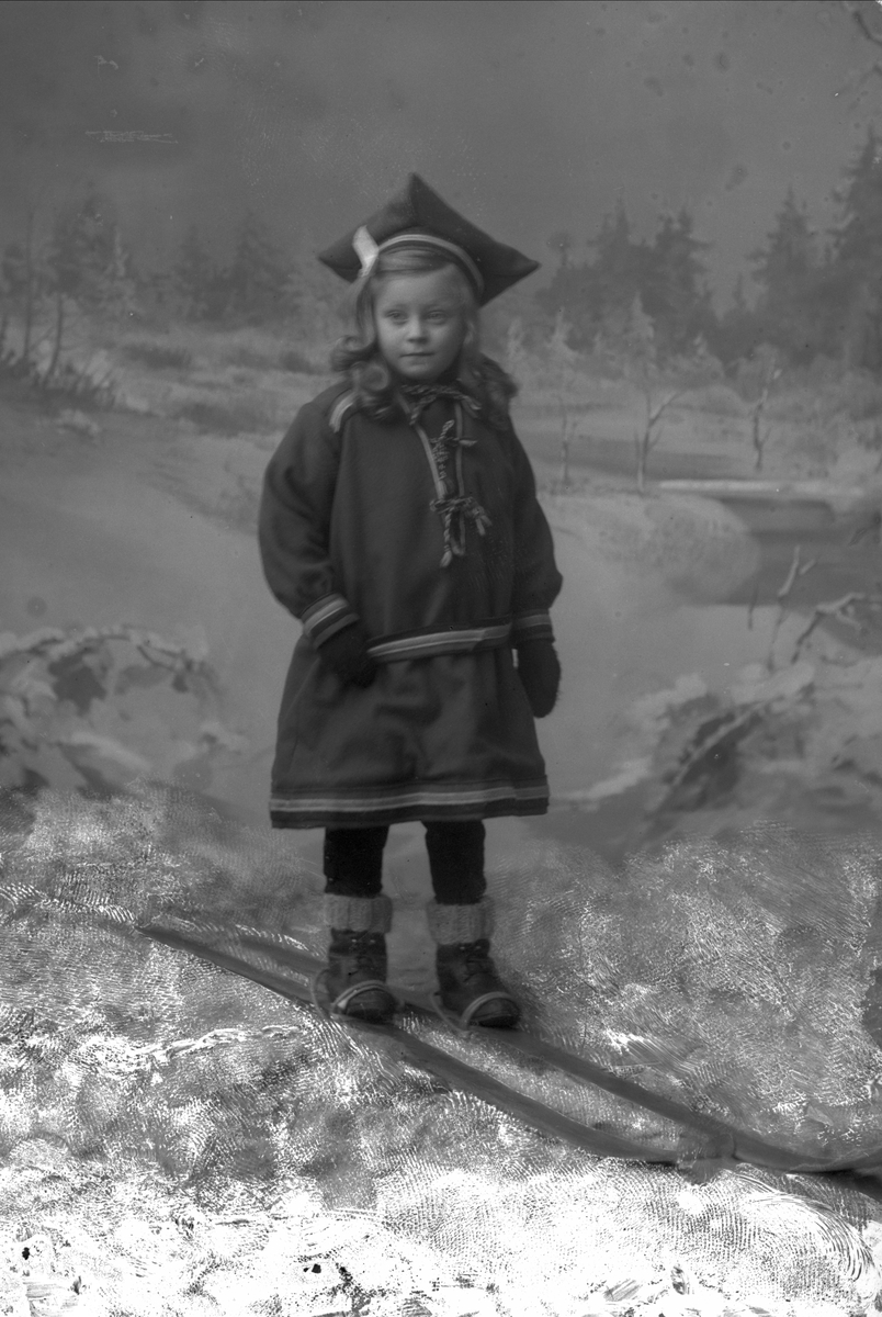 Gustav Borgen, Portrett, liten pike i samedrakt på ski i studio.