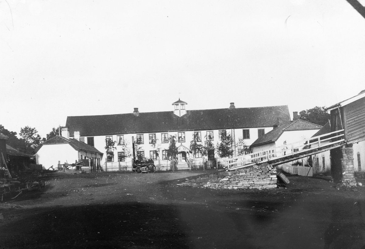 Anno Domkirkeodden, Gårdplassen på Hovinsholm gård, Helgøya. Hovedbygning. Lokomobil for sag og treskeverk. Låvebru.
