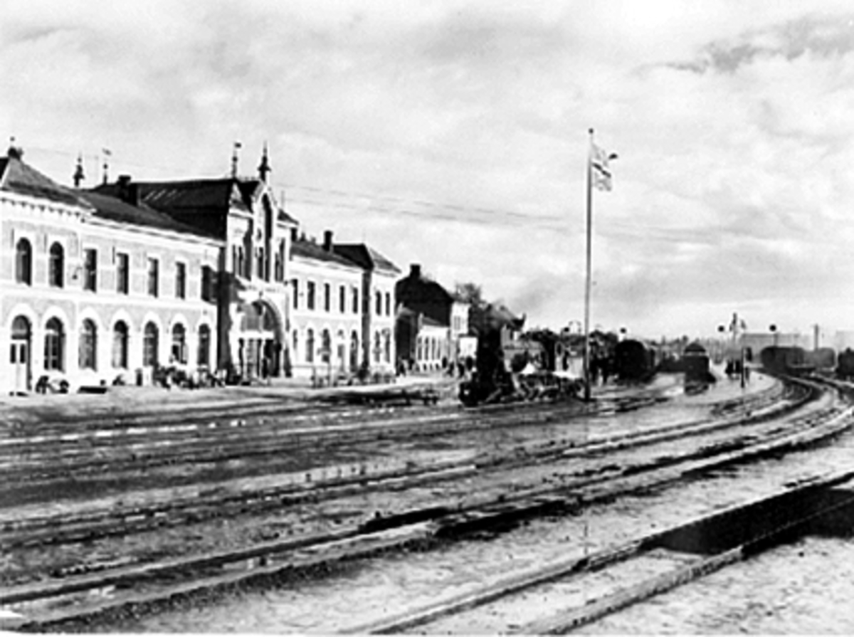 Anno Domkirkeodden, EKSTERIØR STASJONSBYGNING NR. 3 FRA 1896, HAMAR JERNBANESTASJON, TEGNET AV PAUL DUE, JERNBANE I FORGRUNNEN