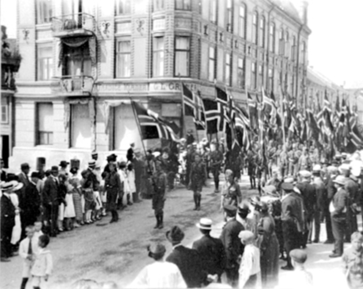 Anno Domkirkeodden, Speidertog gjennom Torggata i forbindelse med landsleir for peidere på Martodden Hamar. Granerudgården, Torggata 32. Flaggparade.