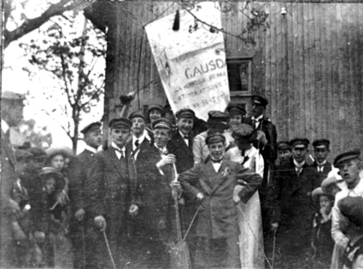 Anno Domkirkeodden, SKOLEBRAKKEN PÅ SKOLETORGET, VESTRE TORG, MANGE RUSS MED FANE, 17 MAI, TEKST PÅ RUSSEFANEN "AA HERREGUD, JEG HAR BARE 19 TIMER AT SOVE I, SÅ HAR VI SLITET IGJEN"