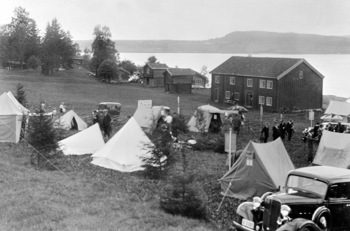 Anno Domkirkeodden, K. N. A. CAMPING-UTSTILLING MED TELT, BILER OG MYE FOLK FORAN LØTENBYGNING. HEDMARKSMUSEET OG DOMKIRKEODDEN. Nærmeste bil: Chevrolet 1933.