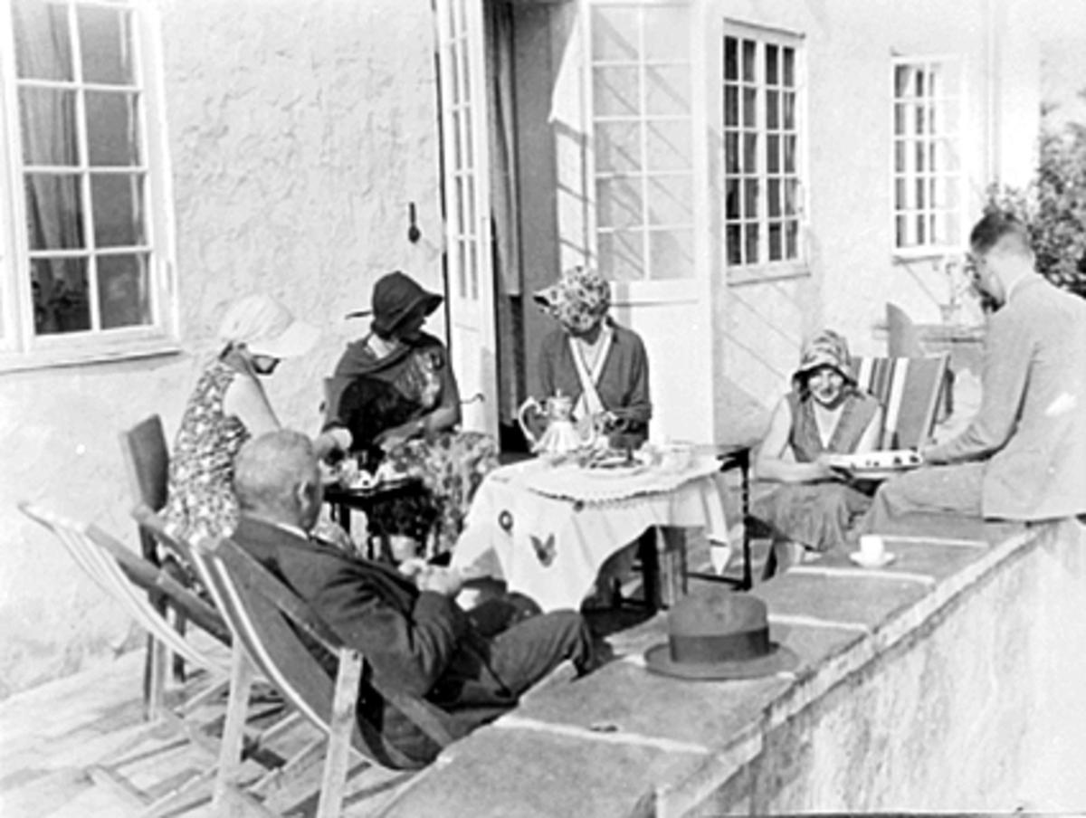 Anno Domkirkeodden, "Hamarhus", Ajer, Kaffeselskap, veranda, hodeplagg,kvinner. F.v. Georg Jacob Stousland, Gig Brinch, Liv Stousland, Karen Sandberg, Tove Stousland, Reidar Brinch.