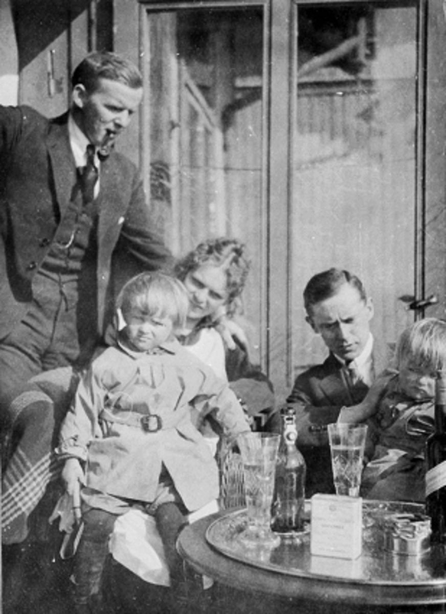 Anno Domkirkeodden, GRUPPE 5 VOKSNE OG BARN PÅ VERANDA, KARL, MARGRETHE OG ALFHILD LØKEN, RAGNVALD BIRCH, KARL ALF LØKEN, BORD MED KOBBERPLATE MED GLASS OG FLASKER, SIGARETTESKE