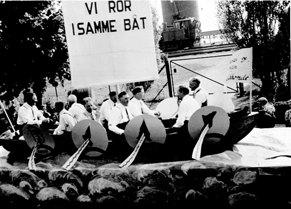 Anno Domkirkeodden, OPPTOG, STRANDGT. , 9 MENN, ROBÅT, TEKST PÅ SEILETTekst på seilet: Vi ror i samme båt.