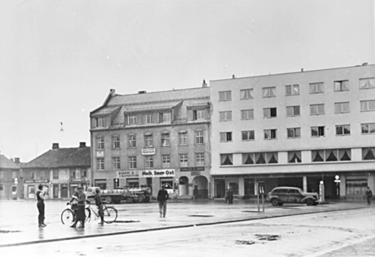 Anno Domkirkeodden, MENN, GUTT M/SYKKEL, ØSTRE TORG, LASTEBIL M/MELKESPANNBaker E. J. Berg, Melkeforsyningsgården og Hotell Astoria.