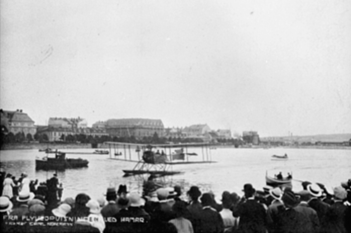 Anno Domkirkeodden, FLYOPPVISNING, SJØFLY, MJØSA, DOBBELDECKER N-6, FRIEDRICHSHAFEN FF. 49, REGISTRERT 1920 ELLER 1921, FLYET EID AV TANCRED IBSEN, GJENNOM FIRMAET A/S AERO, MYE FOLK, FESTIVITETEN UNDER OPPFØRELSE I BAKGR.
