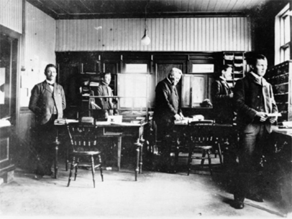 Anno Domkirkeodden, Interiør, Hamar Postkontor, Postmester Hansen, 4 menn. Postkontoret holdt til der Astoria-bygget ved Østre Torg ligger, fra 1901 til 1914. Se 0401-00381 for eksteriør.