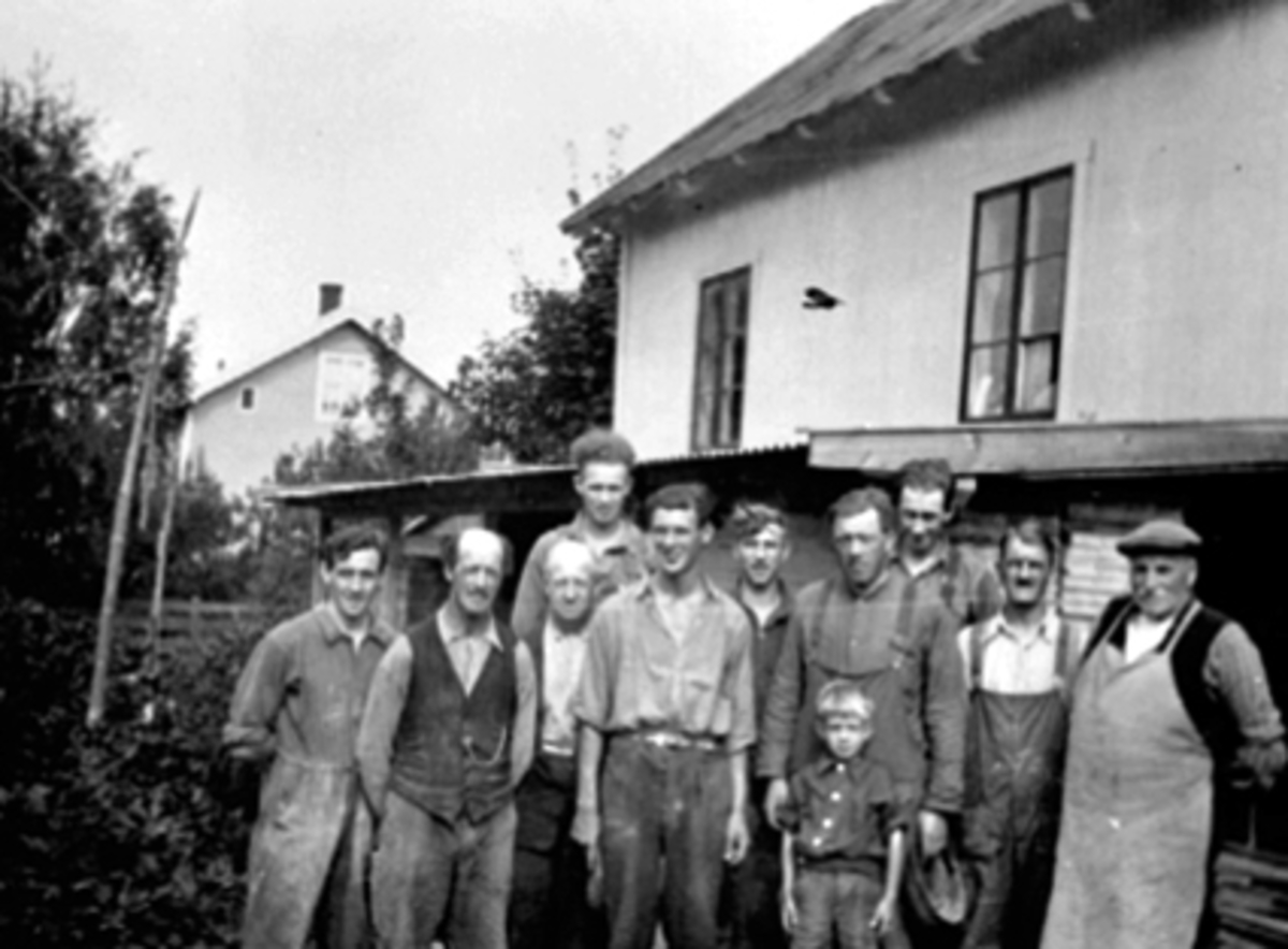 Anno Domkirkeodden, GRUPPE, ARBEIDSTOKKEN HAMARENG SNEKKERFABRIKK, HALVDAN KRISTANSENHalvdan Kristiansen nr. 4 fra h. med sønnen Bjørn foran seg. Olaf Kristiansen bak. Nr. 3 fra h. svogeren til Halvdan. Halvdan Kristiansen eide verkstedet. Se reg. skjema for flere navn.