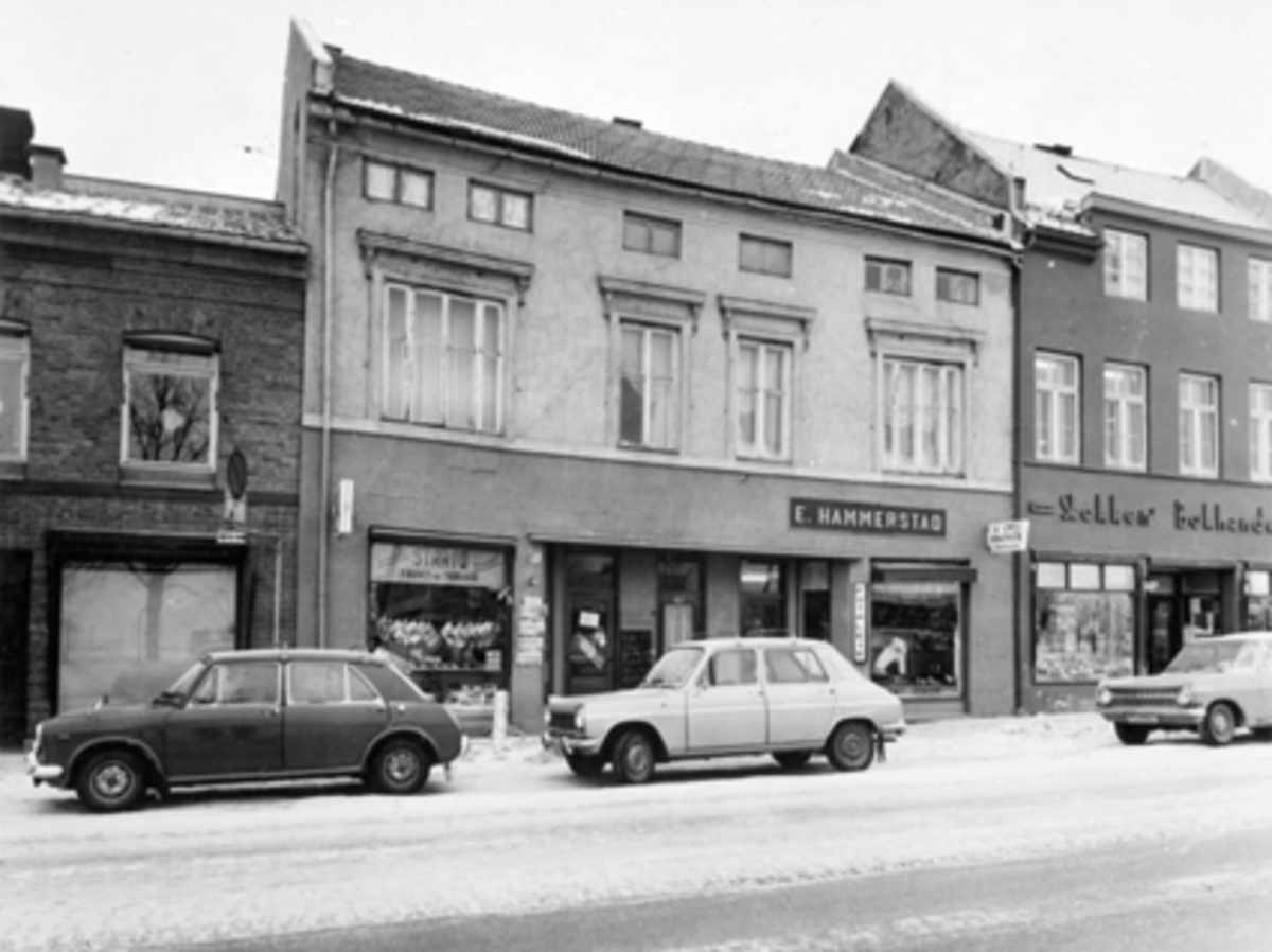 Anno Domkirkeodden, EKSERIØR:STRANDGT. 13, FRUKT & TOBAKK, E. HAMMERSTAD, STØKKEN BOKH. Bilene forfra: Trolig Austin eller Morris 1100, Simca 1100, Opel Rekord A årsmodell 1963-65.
