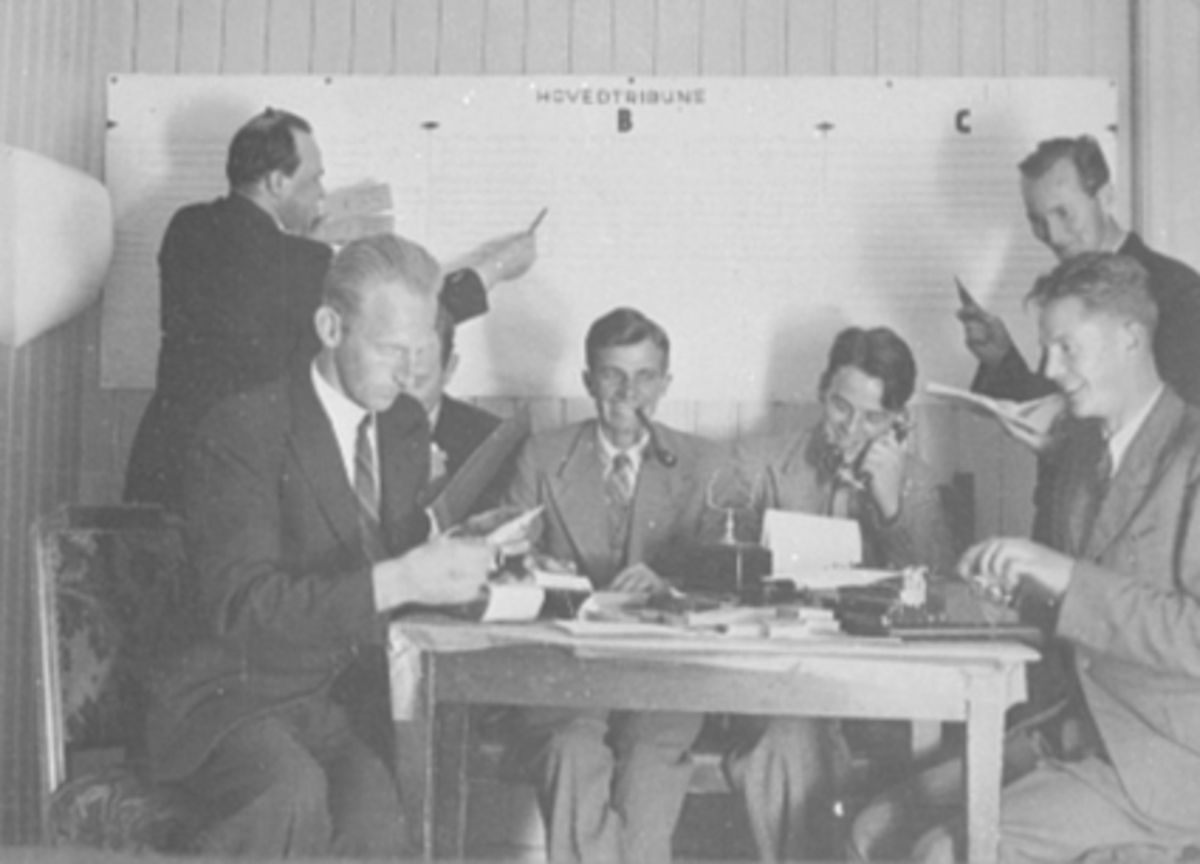 Anno Domkirkeodden, GRUPPE 7 MENN, FINALEKOMITEEN, HAMARKAMERATENE, HAM-KAM, FORAN FRA VENSTRE: HJALMAR JOHNSON, UKJENT SKJULT: INGVALDSEN ?, HJALMAR JOHANSEN MED PIPE, ARVID ARNESEN MED TELEFON, OSCAR OLAUSEN MED SKRIVEMASKIN, BAK FRA VENSTRE: ASBJØRN STEINAA OG ALF BERGDUBLETT 401-6073