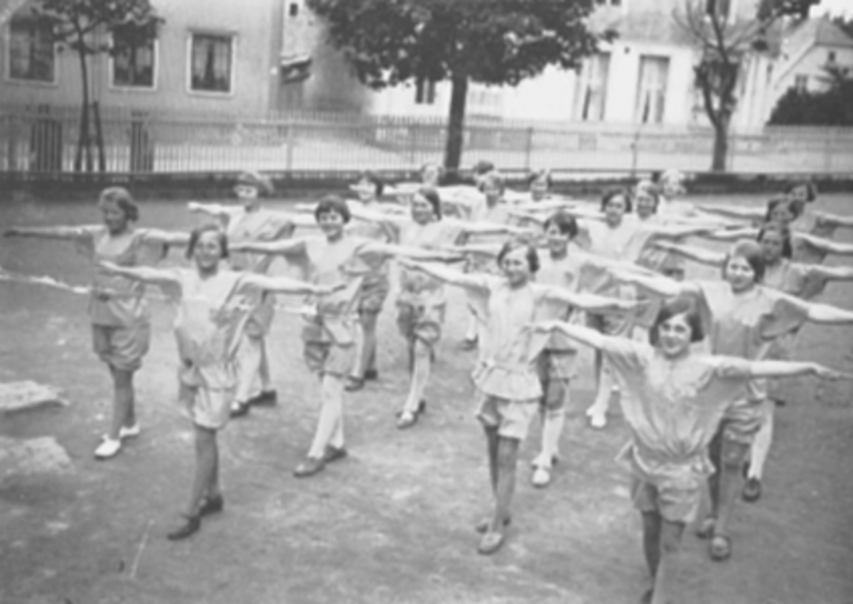 Anno Domkirkeodden, Hamar folkeskole. Jenteturnere fra 5 klasse 1934. Bokstaven på brystet sto for fri, frank, fro, freidig. Louise Kjøniksen og Gerd Sydhagen er bl. andre med blandt turnerne. Ukjent plassering. Linjegymnastikk.