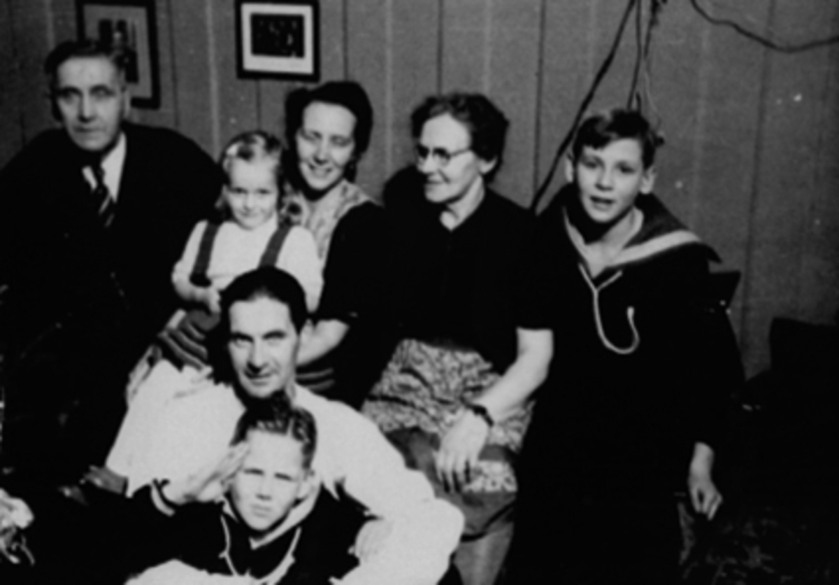 Anno Domkirkeodden, GRUPPE 7, BAK FRA VENSTRE: TEKNISK TEGNER PÅ HAM-JERN: MARTIN LARSEN, DATTER MARIE LARSEN MED HANNE MORTENSEN PÅ FANGET, MARIE LARSEN OG SØNNEN TIL MARIE, FORAN: LEIF BORCK LARSEN OG MARIES SØNN NR. 2, STØPERIGÅRDEN, JULEKVELD I WELHAVENS GATE 14. GUTTENE MED MATROSDRESSER ER BARNEBARN.