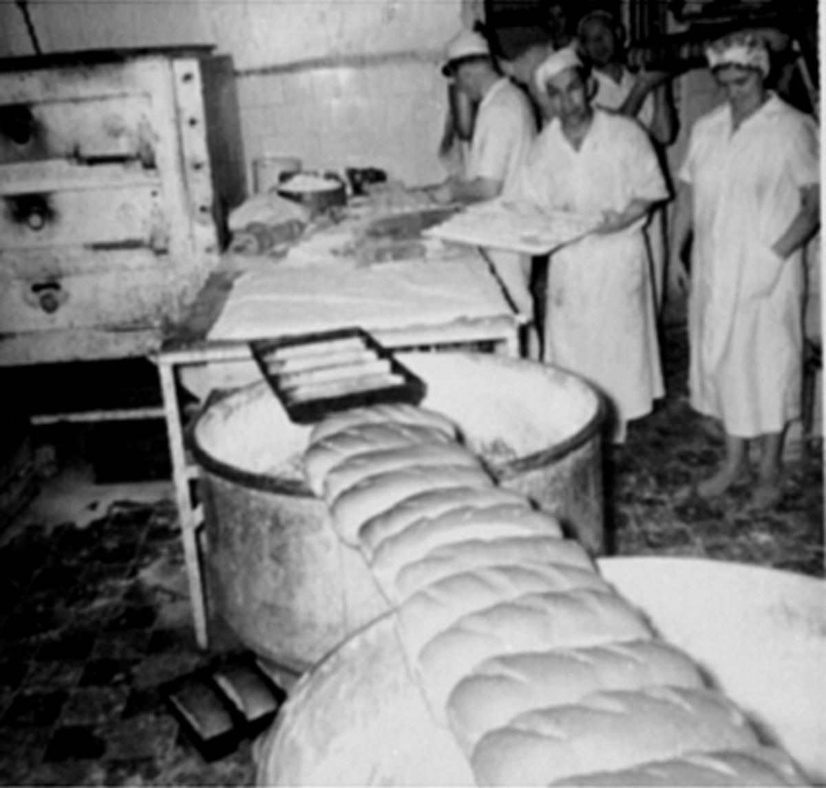 Anno Domkirkeodden, INTERIØR BAKERI DIDRICHSEN I ÅSGÅRDEN, GRISLEBRØD BAKES, BAKERE FRA HØYRE: JENNY ENGH OG OSCAR ELVERHØI, VED ARBEIDSBORDET: SVERRE SEBERG, BAK MED BRØDBRETT: ROLF ØSTBY, BAK I DØRA: GRETHE MYHRE