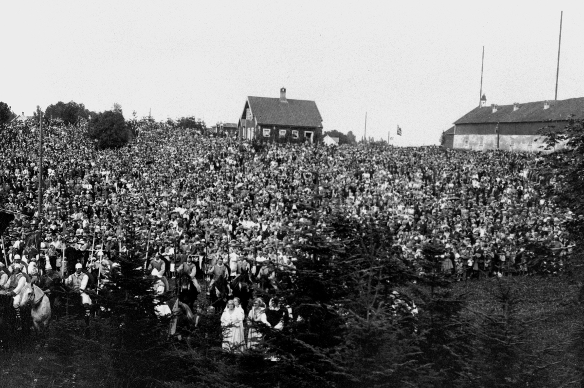 Anno Domkirkeodden, Teateroppsetning, historisk teater, på uteområdet på Domkirkeodden. Riddere til hest i forgrunnen. I bakgrunnen ligger Storhamarlåven. Et folkehav er samlet i hellinga rundt og nedenfor den gamle restauranten. Hedmarksmuseet og Domkirkeodden.