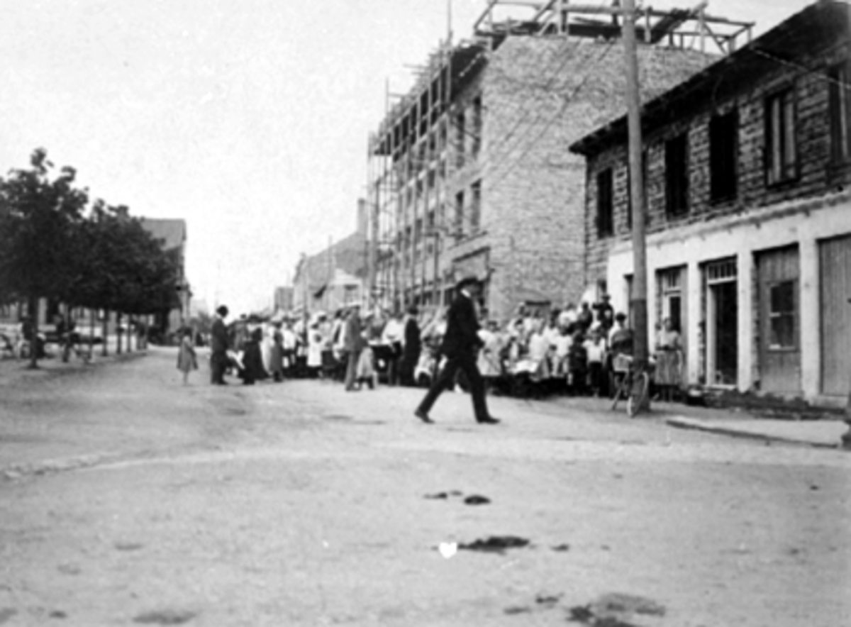 Anno Domkirkeodden, VANGSVEGEN 23, MELKEFORSYNINGSGÅRDEN BYGGES OPP ETTER BRANN 1917, FOLK STÅR I KØ FOR Å FÅ MELK