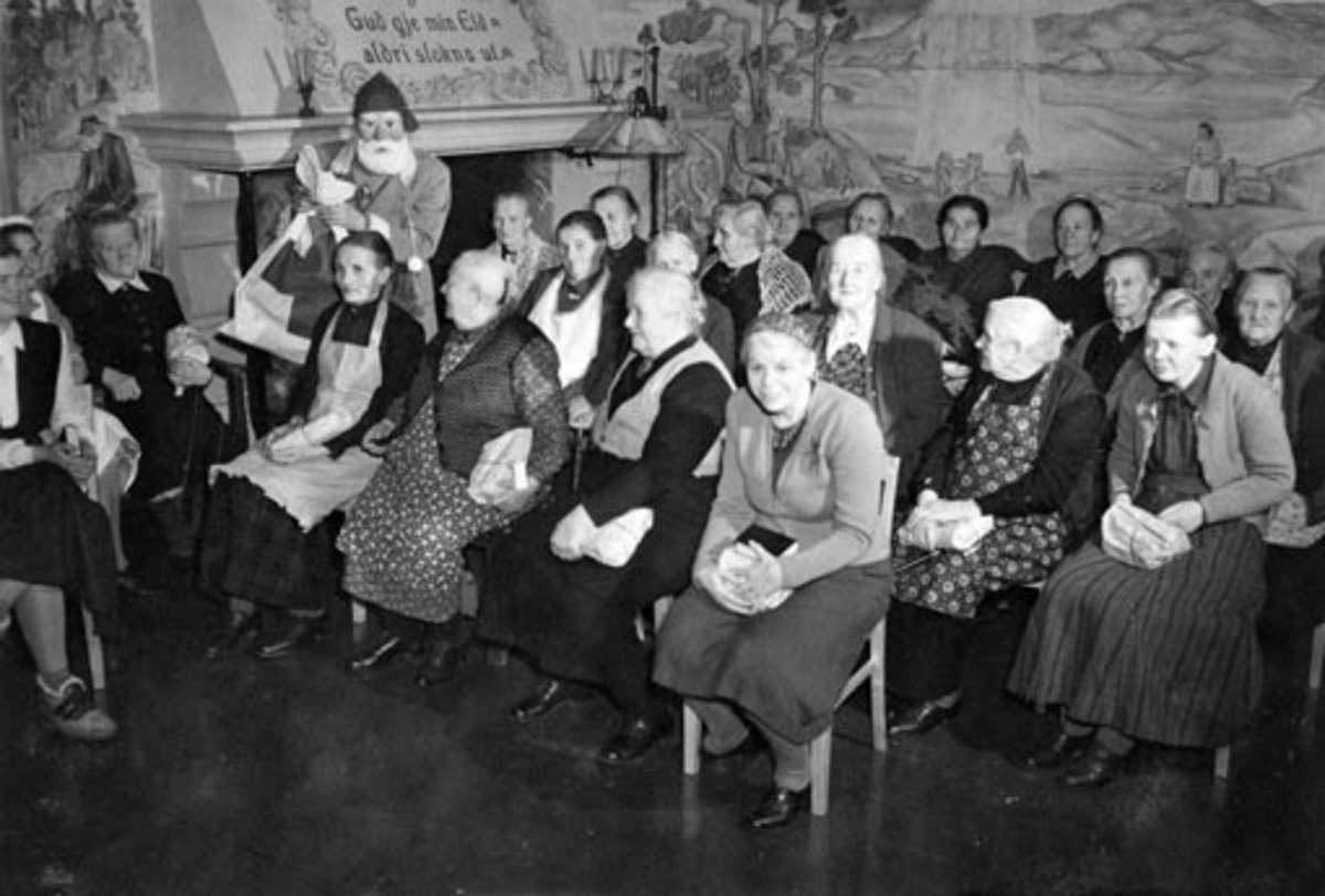 Anno Domkirkeodden, HAMAR RØDE KORS ARBEIDSGRUPPE 4, DELER UT JULEGAVER PÅ GAMLEHJEMMET. JULENISSE OG BEBOERE. HAMAR SYKEHJEM. FOTO NORMANN, HAMAR 18. 12. 1949 SE OGSÅ NEG. NR. NO 37505