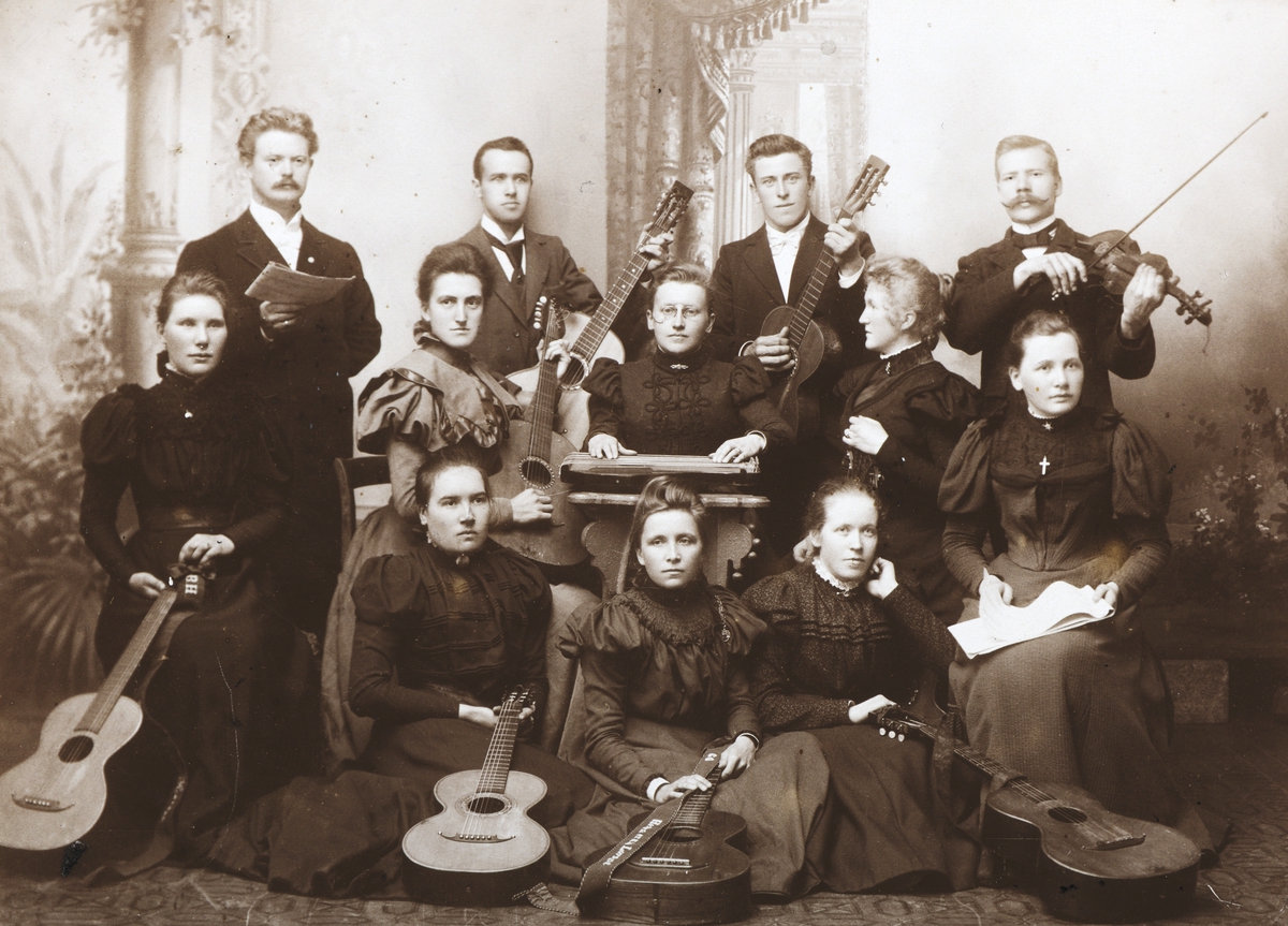 Ukjent, Metodistkirken i Hamar. Strengemusikken 1901. Instrumenter, musikere, strykeorkester. Foran: Inga Høisveen, Gustava Olsen, Ukjent dame. 2. rad :Berthe Hansen, Karelie Bergithe Kraabøl-Larsen, Gitta Bergh, Emma Larsen Røtvold, Gina Jensen. 3. rad : Pastor H. K. Madsen, Olaf Halvorsen, Pastor Oscar S…