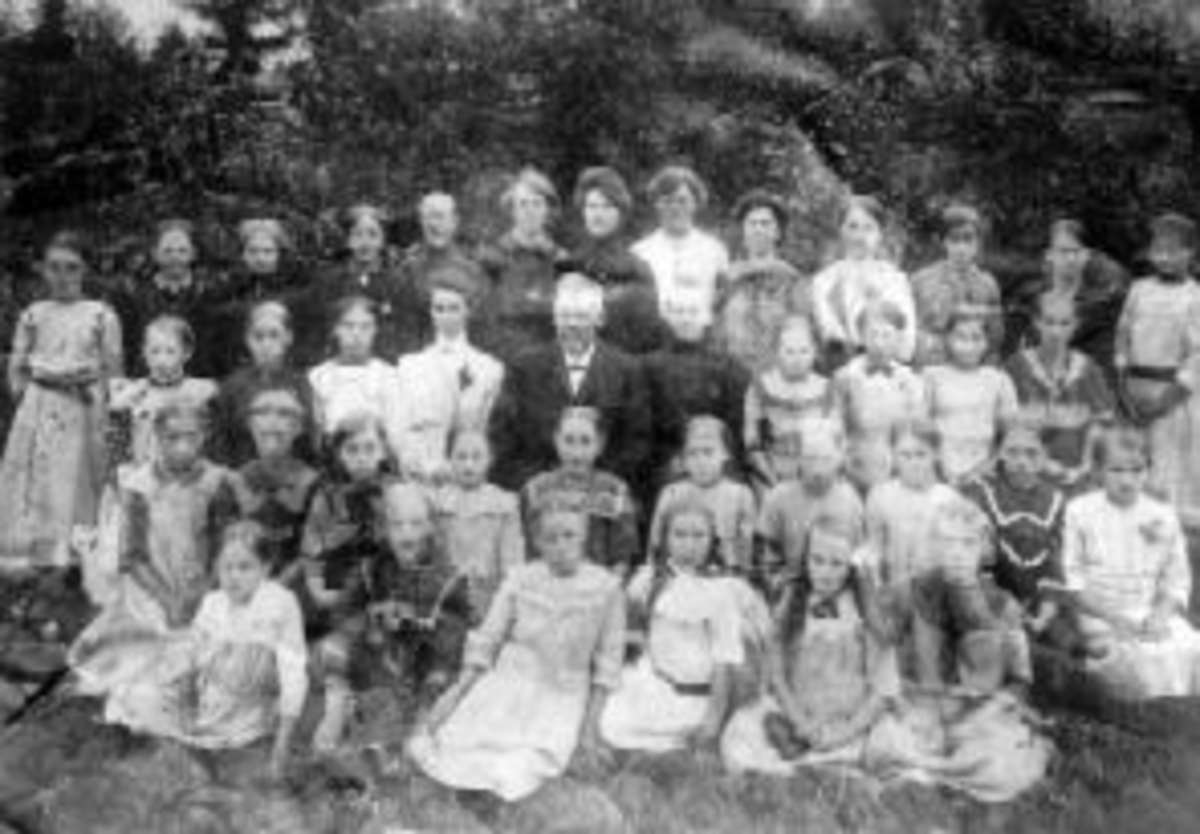 Anno Domkirkeodden, Betanien barne og ungdomsforening på Bakkerud, Kylstad, Furnes. Misjonsforeningen hadde møter her til Betaninen bedehus ble bygd omkring 1913. Leder Pastor L. Jensen (1848-1921), pensjonert metodistprest. Bakerste rad fra venstre er Agnes Opsahl, Helga Schwabe, Sunda Hoeln, Olaug Gålås, Agnete Aspe…