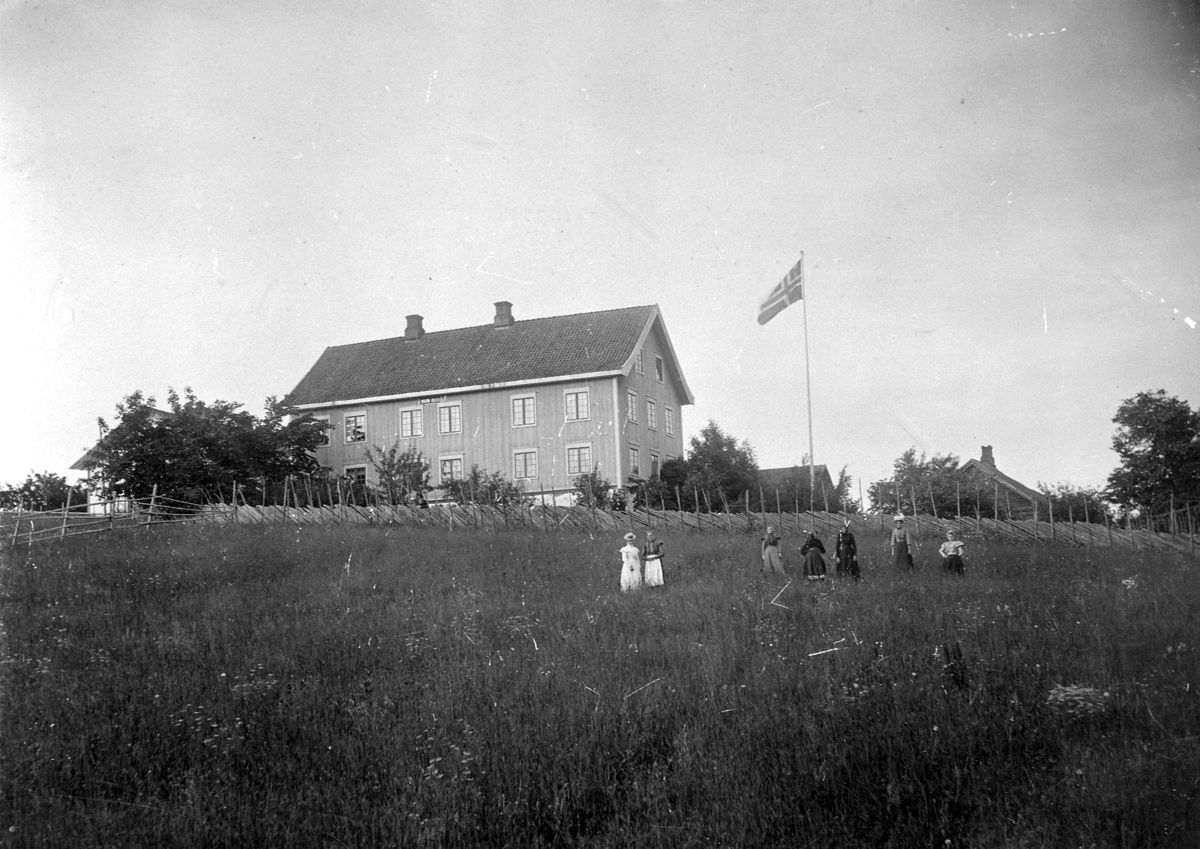 Anno Domkirkeodden, Eksteriør, gardsbruk, Maurud gård, hovedbygningen. Unionsflagg. Sju damer i åkern.