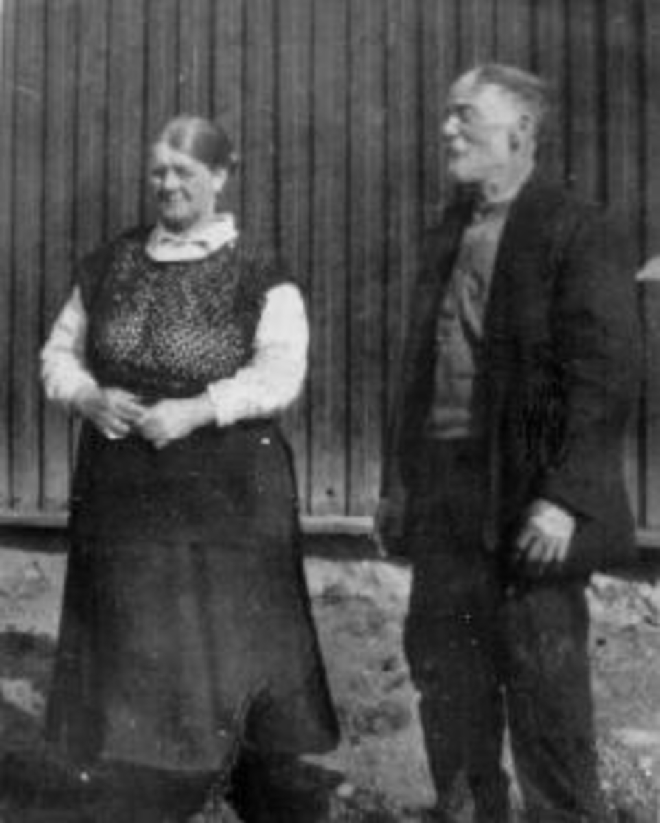 Anno Domkirkeodden, Antonie Olsdatter Bakken (1870-1951) og Helmer Martinsen Bakken (1864-1939) utafor huset i Bakken (Nerbakken), Helgøya. De bodde i Nerbakken fra 1905 til 1939 da Helmer døde. Hun levde mange år etter. Helmer og Antonie Martinsen Bakken kjøpte Nerbakken i 1906.