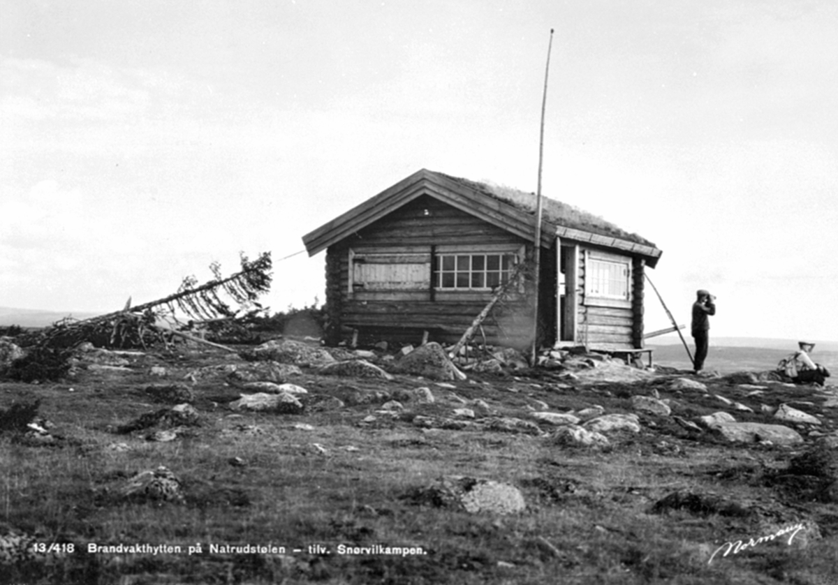 Anno Domkirkeodden, Eksteriør, Natrudstilen brannvakthytte, Ringsaker Almenning. Brannvakt Olaf Bekkelund med kikkert. Hytta ble ombygd i 1951-52. Den hadde telefonforbindelse med Brumundkampen og Knutberget i Stange. Hedemarksalmenningene eide alle vaktstasjonene.