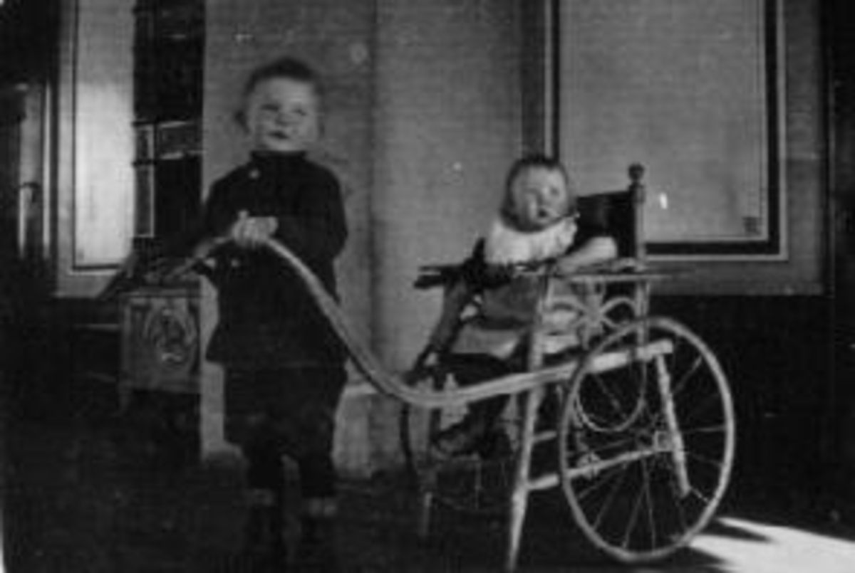 Anno Domkirkeodden, To barn. Even Bogsti trekker Gunvor Storlien i stolvogn med langt håndtak. Gutt kjører jente i vogn. Jentene i familien fikk navnet etter faren som het Storlien, og guttene etter garden Bogsti som de vokste opp på. Hilsen barnebarn til Even.