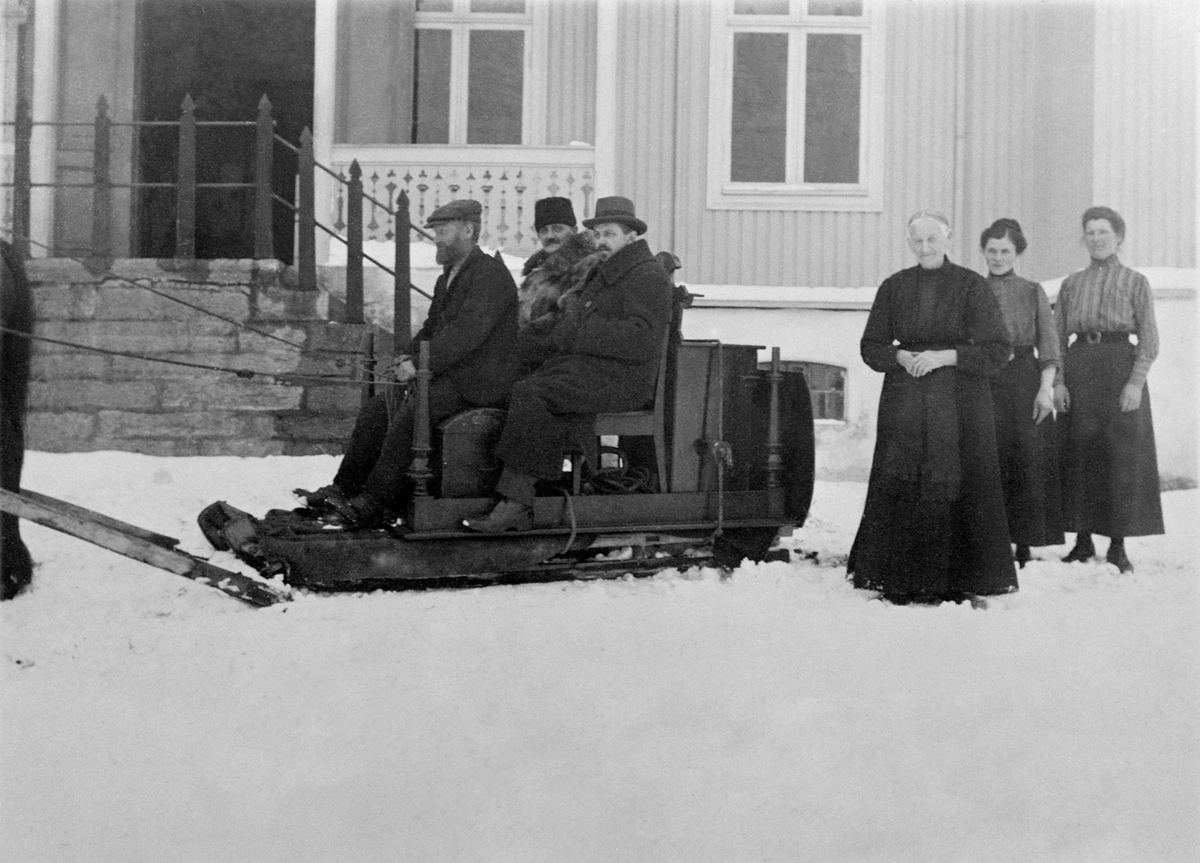 Anno Domkirkeodden, Hest med slede og flyttalass. Johannes Staf kjører sleden. J. Røhr og Halfdan Skappel f.1876 på sleden. De tre damene er Eli Skappel f.1849, Marie Kristiansen f.1895, Agnethe Evenstad f.1880. Ringsaker Sparebank flytter fra Tingvang til Moelv.