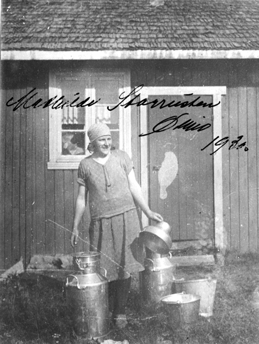Anno Domkirkeodden, Mathilde Storrusten i arbeidsklær med melkespann på Øimo, Moelv.