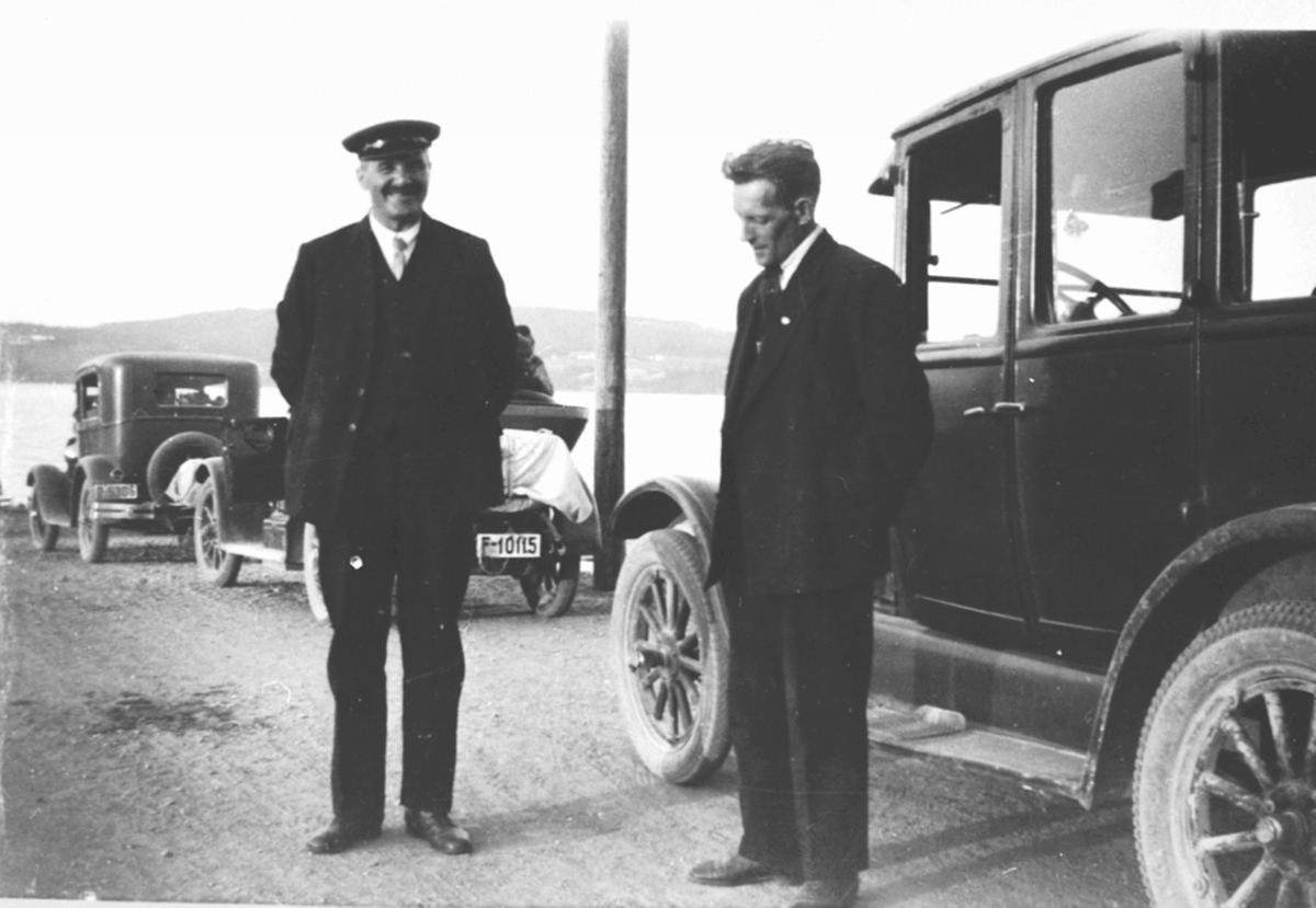 Anno Domkirkeodden, Biler og folk venter på ferje ved Mengshoel fergested. Mikkelsen fra Furnes er sjåføren. Den andre er ukjent.