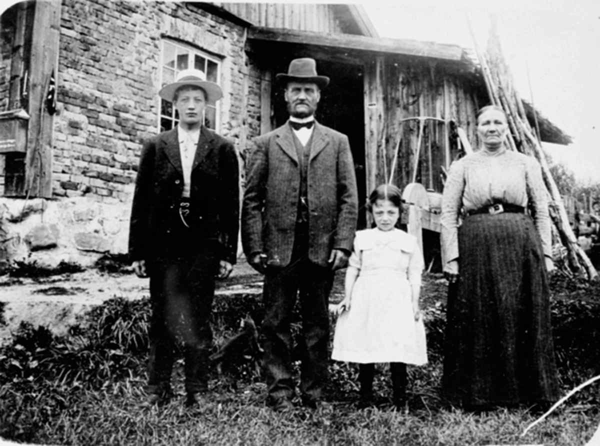 Anno Domkirkeodden, Voksne og barn utenfor huset i Karlstad, Mengshol. Fra venstre er Theodor Johnsen f.1897, husmann og teglbrenner Ole Andreasen, Gudrun Kristiansdatter f.1908, Eline Evensdatter f.1856. Huset er delvis bygget i halvsteinsmur. Ole Andreasen var husmann på Mengshol i 50 år.