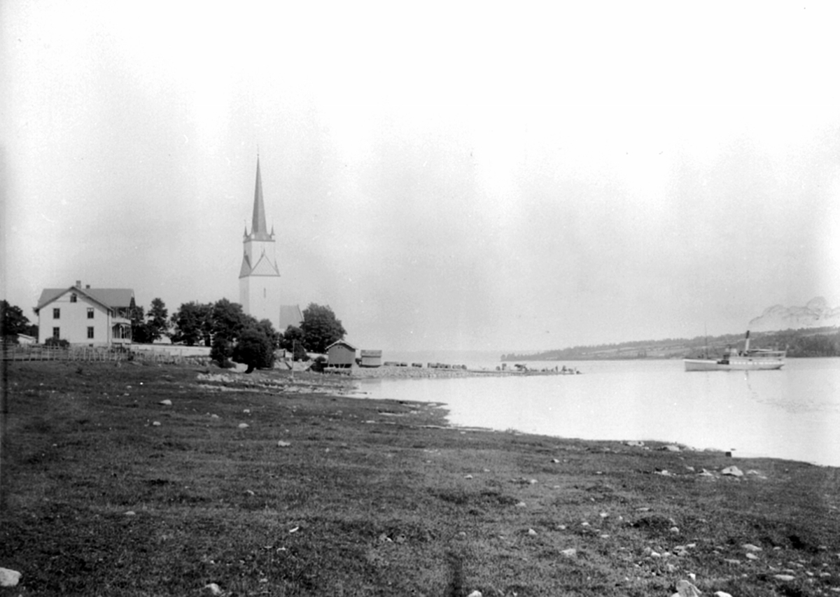 Anno Domkirkeodden, Mjøsbåten D.S. Gjøvik på vei inn mot Nes brygge på Tingnes, Hedmark. Det gamle kommunelokalet til venstre. Nes kirke.