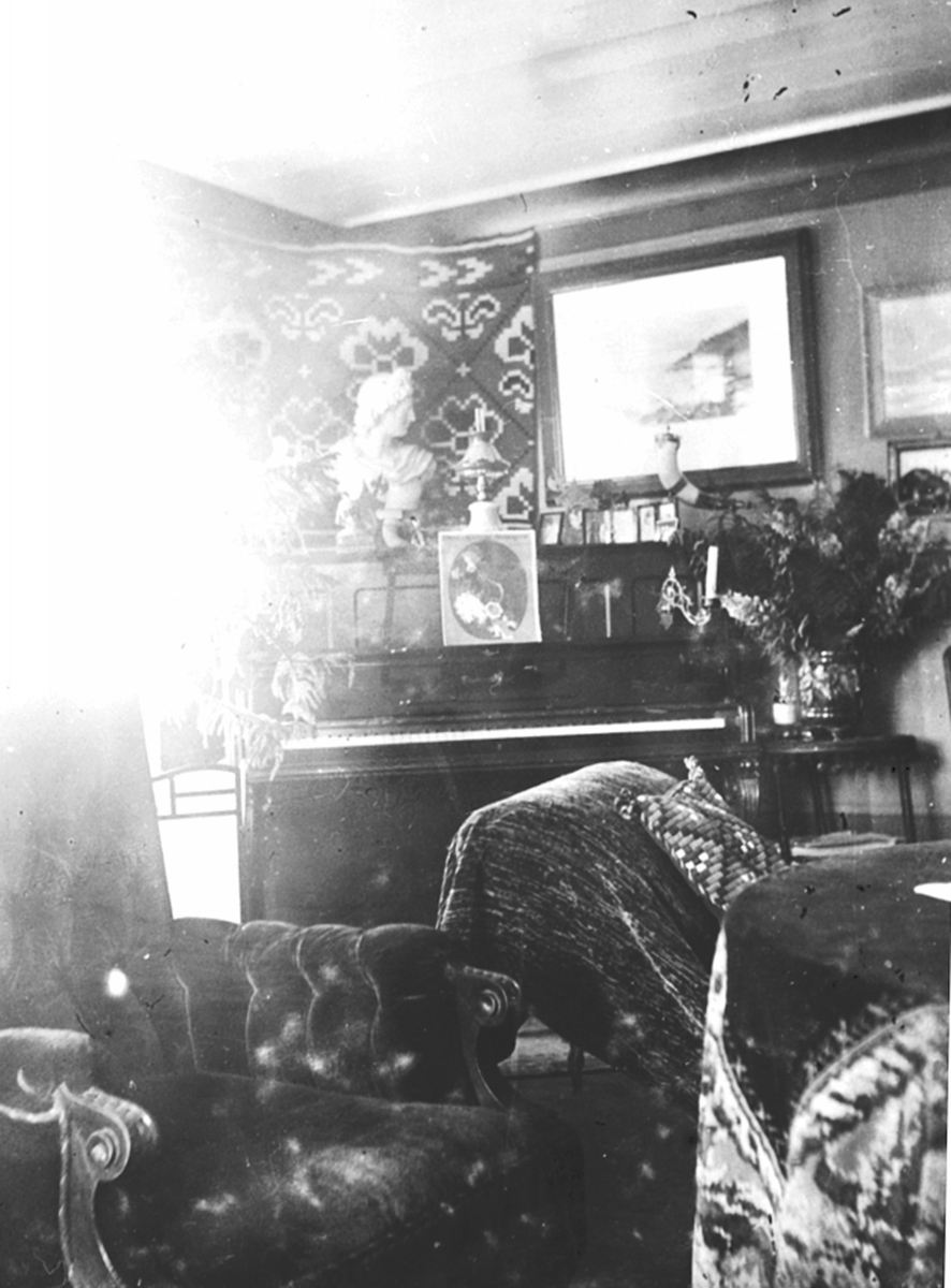 Anno Domkirkeodden, Interiør, stue, hos doktor Karl Løken på Granerud gård, Brumunddal. Piano, skulptur, bilder, møbler.
